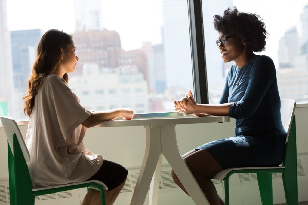 two women talking at a table