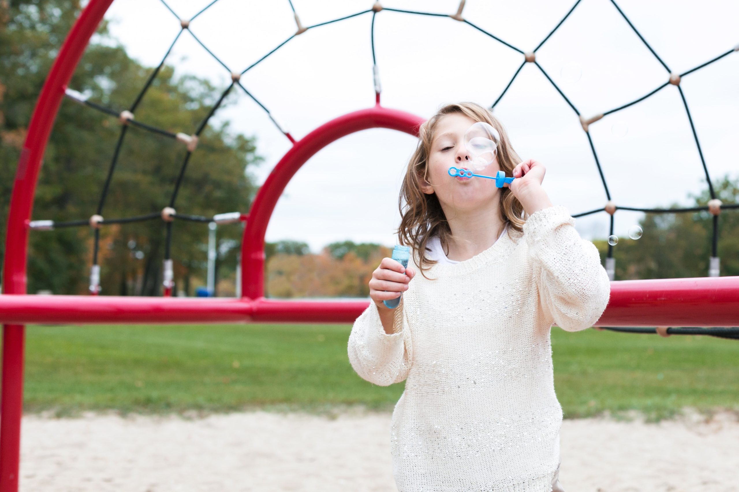 girl-blowing-bubbles-at-park